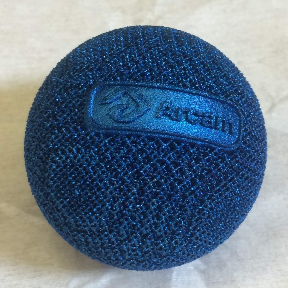 Electroplated titanium mesh ball with embossed logo designed for Arcam CAD To Metal (2017)