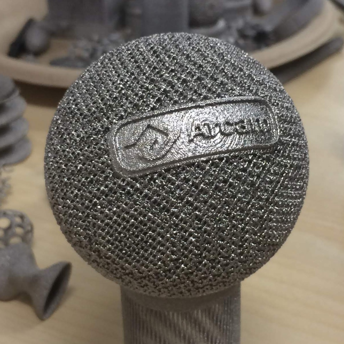 Electroplated titanium mesh ball with embossed logo designed for Arcam CAD To Metal (2017)